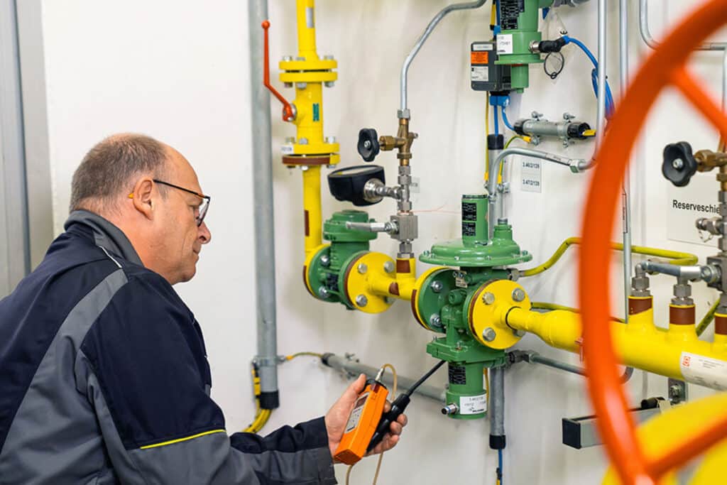 Ein Anlagenmechaniker übernimmt eine Messung.