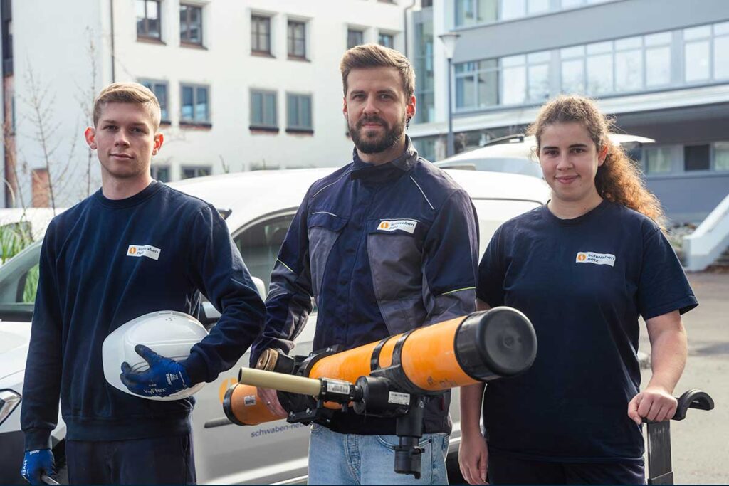 Eine junge Frau und zwei junge Männer bei der Arbeit in der Anlagentechnik.