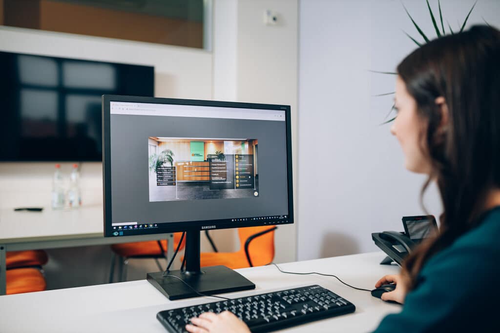 Eine junge Frau scrollt am PC durch die Webseite von energie schwaben.