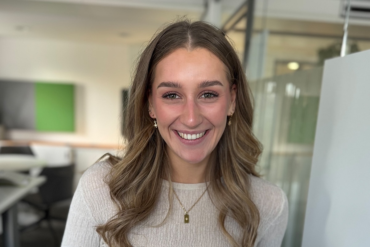 Auszubildende Vanessa lächelnd im Büro.