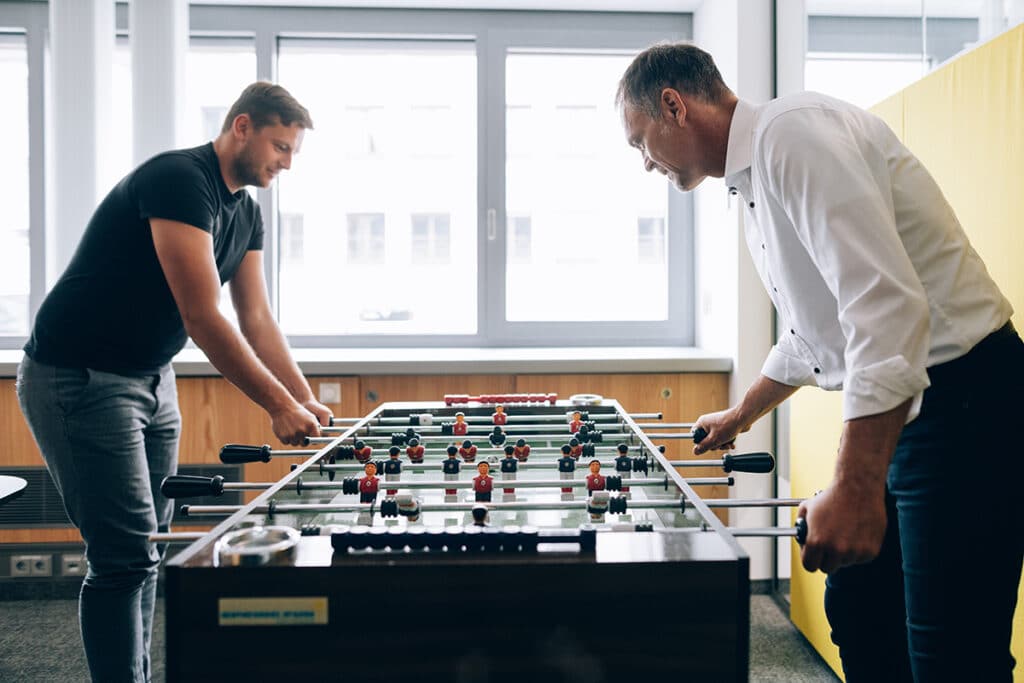 Zwei Männer spielen beim Energieversorger energie schwaben Kicker.