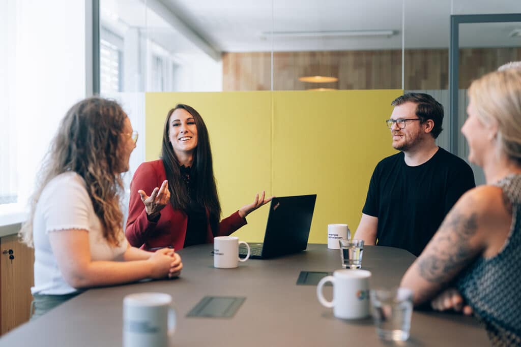 Mitarbeitende im Energieunternehmen energie schwaben unterhalten sich lebhaft.
