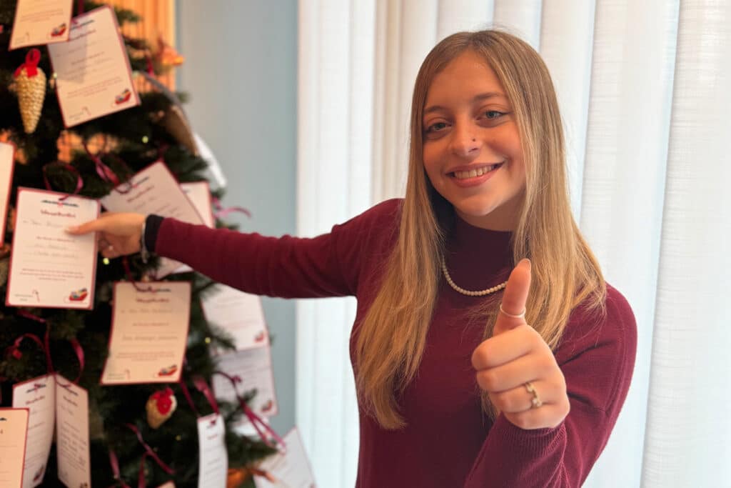 Unsere Auszubildende Ambra bringt die Wunschzettel der Seniorinnen und Senioren an den Weihnachtsbaum – aufgenommen im Rahmen unserer diesjährigen Weihnachtsbaumaktion.