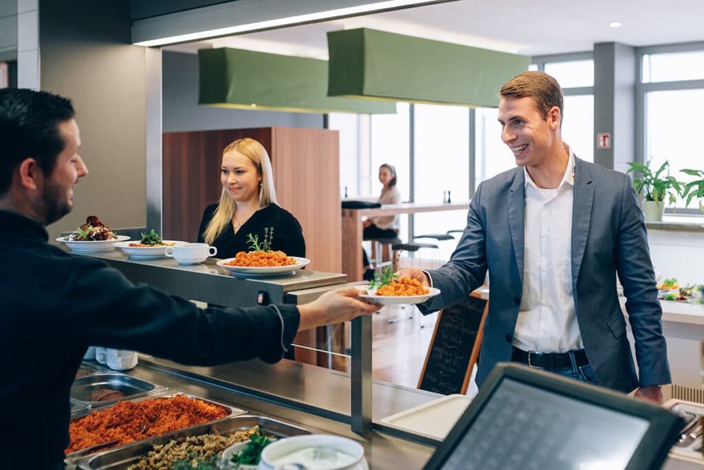 Ein Mitarbeiter bei energie schwaben genießt die Vorteile einer Betriebskantine.