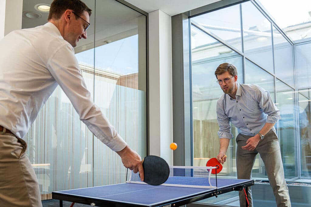 Zwei Mitarbeiter von energie schwaben spielen Tischtennis.