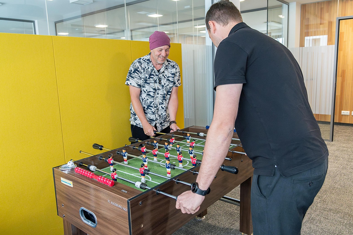 Zwei Männer spielen an einem Kicker-Tisch.